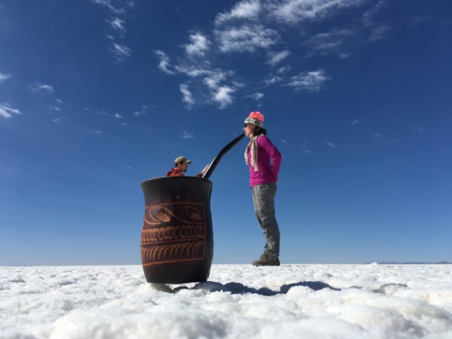 A giant drinking maté with her little helper